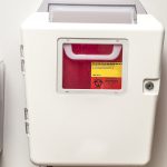 Sharps container on the wall of a patient room in a hospital or doctors office